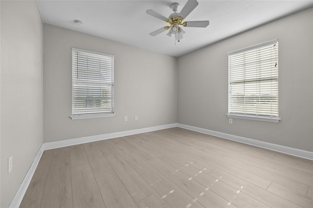 empty room with baseboards, ceiling fan, and wood finished floors