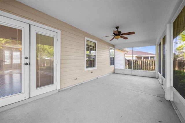 unfurnished sunroom featuring french doors, ceiling fan, and a healthy amount of sunlight