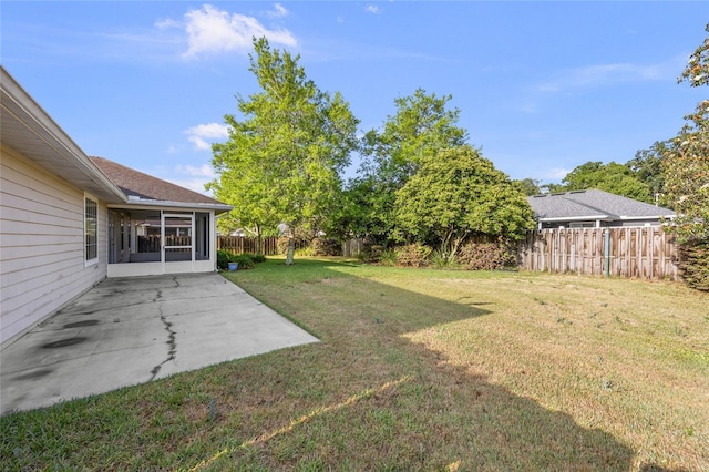 view of yard featuring a sunroom, a fenced backyard, and a patio area