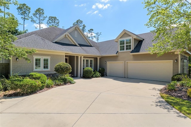 view of front of house featuring roof with shingles, an attached garage, and concrete driveway