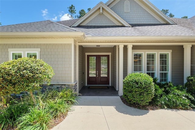 doorway to property featuring french doors and a shingled roof