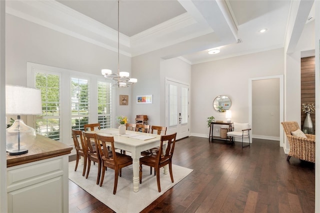 dining space featuring a towering ceiling, dark wood finished floors, baseboards, a chandelier, and ornamental molding