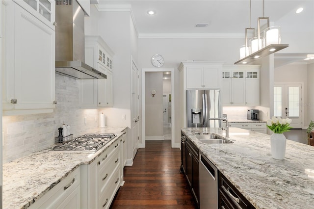 kitchen featuring dark wood-style flooring, light stone countertops, wall chimney range hood, a sink, and appliances with stainless steel finishes