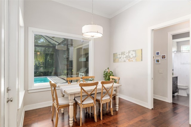 dining room featuring crown molding, baseboards, and dark wood-type flooring