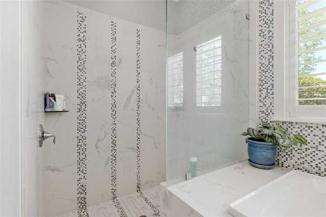 bathroom with a tile shower and a wealth of natural light