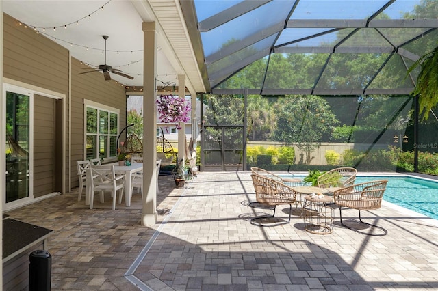 view of patio with a fenced in pool, glass enclosure, outdoor dining area, and ceiling fan