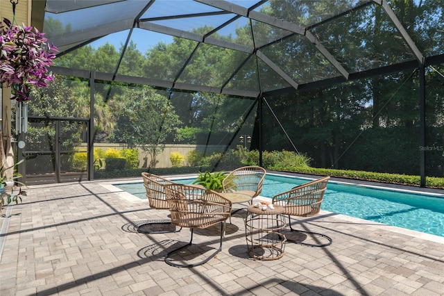 outdoor pool featuring glass enclosure and a patio area