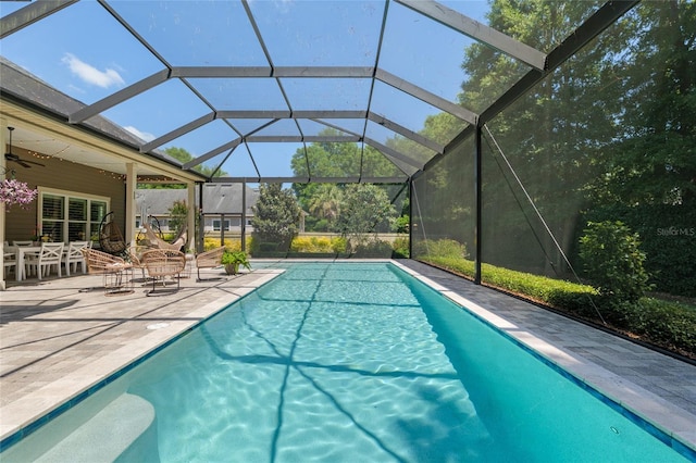 outdoor pool featuring glass enclosure, a ceiling fan, outdoor dining area, and a patio area