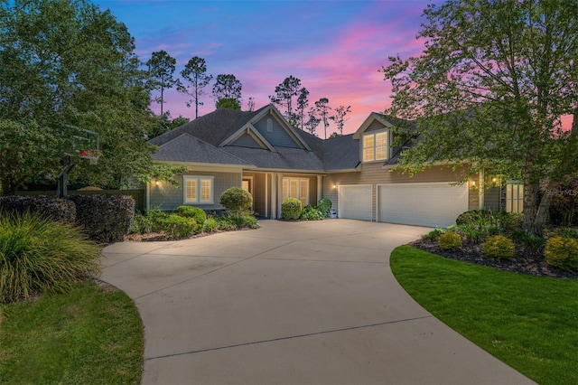 traditional-style home with driveway, a front yard, and a garage