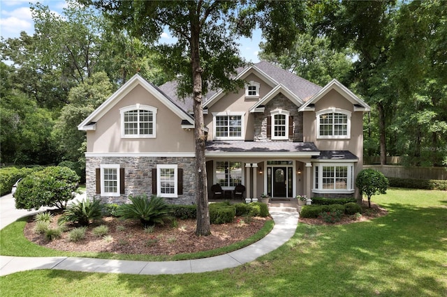 4515 SW 97th Ter, Gainesville, FL 32608 - traditional-style house with stone siding, stucco siding, and a porch