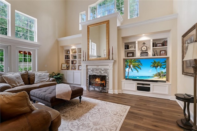 4515 SW 97th Ter, Gainesville, FL 32608 - living area featuring a towering ceiling, a tiled fireplace, built in shelves, dark wood finished floors, and baseboards