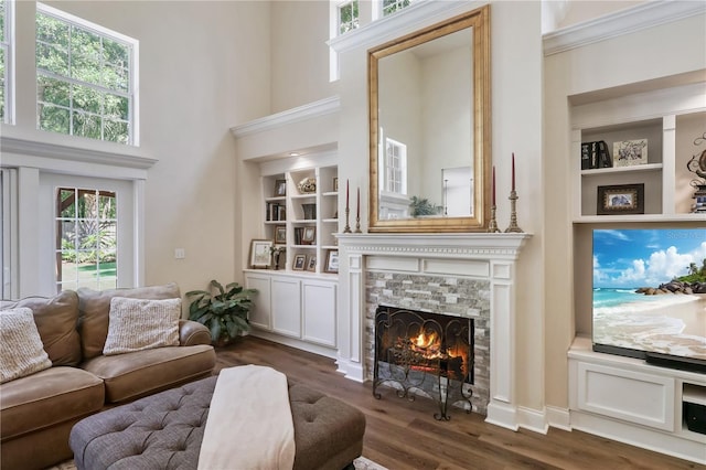 4515 SW 97th Ter, Gainesville, FL 32608 - living area with a tile fireplace, built in features, dark wood finished floors, crown molding, and a towering ceiling