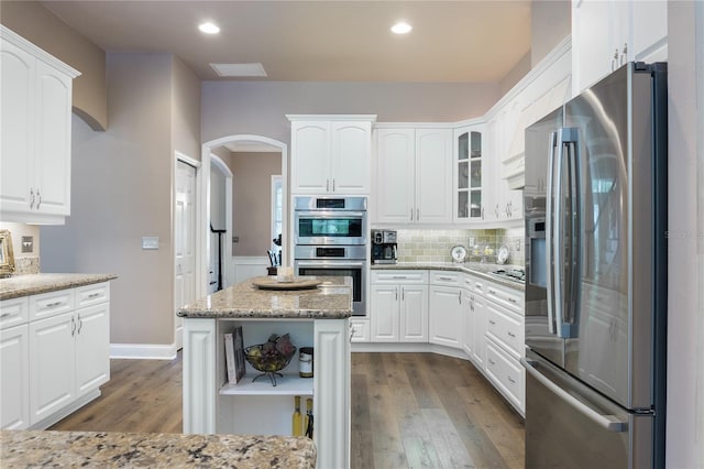 4515 SW 97th Ter, Gainesville, FL 32608 - kitchen with stainless steel appliances, open shelves, dark wood-type flooring, arched walkways, and recessed lighting