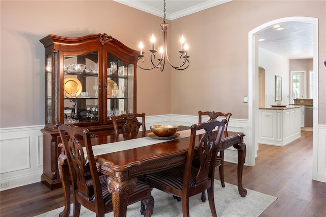 4515 SW 97th Ter, Gainesville, FL 32608 - dining room with arched walkways, wainscoting, a chandelier, light wood-style flooring, and a decorative wall