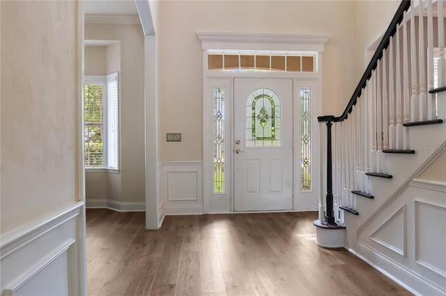 4515 SW 97th Ter, Gainesville, FL 32608 - foyer with wood finished floors, a decorative wall, stairway, a wainscoted wall, and ornamental molding