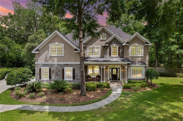 4515 SW 97th Ter, Gainesville, FL 32608 - traditional-style house featuring stone siding, stucco siding, and a yard