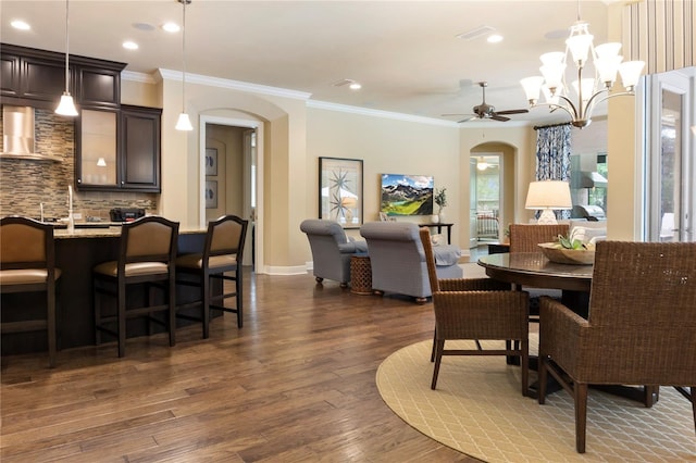 dining room with arched walkways, ceiling fan, dark wood-style flooring, crown molding, and recessed lighting