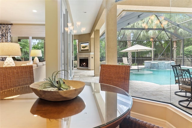 dining room with a warm lit fireplace and a sunroom
