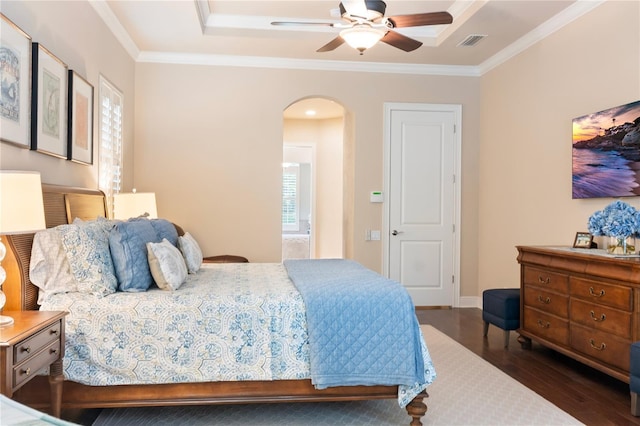 bedroom with arched walkways, wood finished floors, ornamental molding, and a ceiling fan