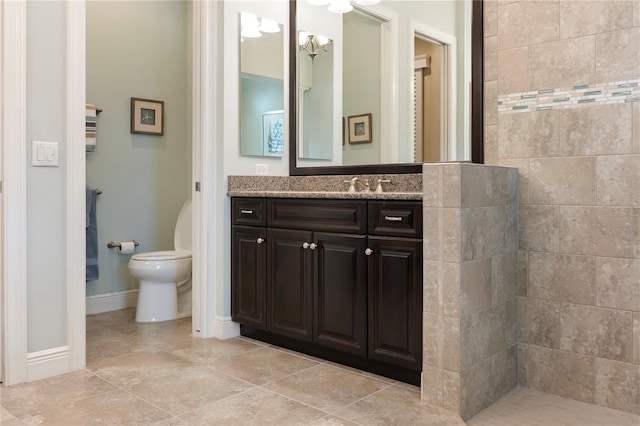 full bathroom with toilet, baseboards, vanity, and walk in shower