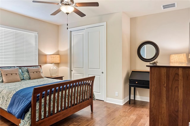 bedroom with wood finished floors, baseboards, a closet, and ceiling fan