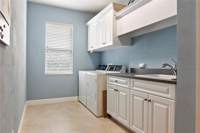 washroom with separate washer and dryer, cabinet space, baseboards, and light tile patterned floors