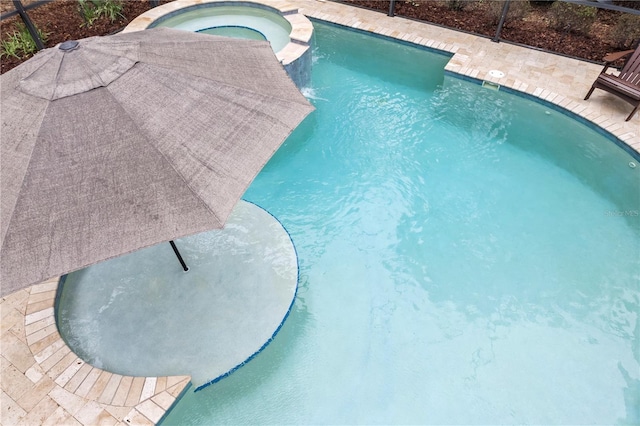 view of swimming pool featuring a pool with connected hot tub and a patio area