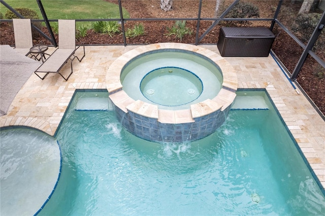 view of pool with a pool with connected hot tub, glass enclosure, and a patio