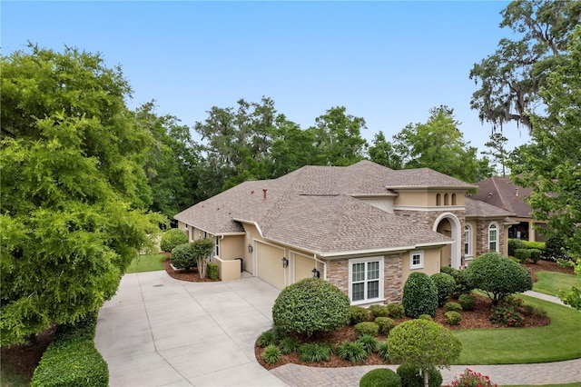 view of front of property with stone siding, driveway, stucco siding, and a garage