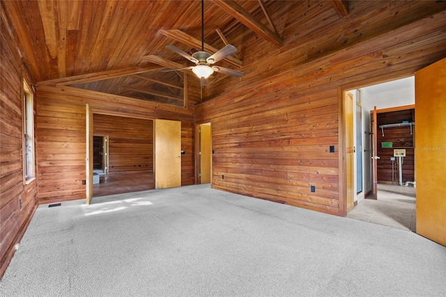 spare room featuring carpet floors, wood ceiling, ceiling fan, and wooden walls