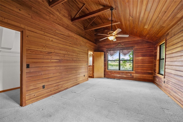 empty room featuring wooden ceiling, lofted ceiling with beams, and wood walls