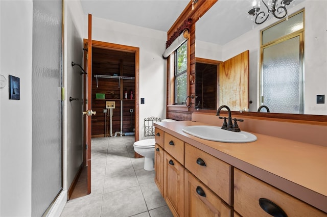 full bath with a notable chandelier, a shower with shower door, vanity, toilet, and tile patterned floors