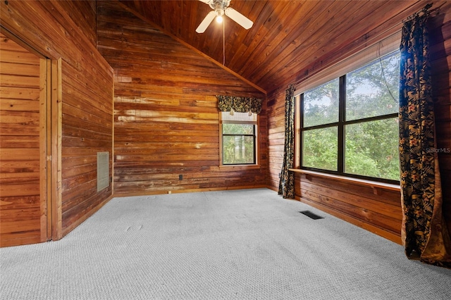 carpeted empty room featuring wood walls, visible vents, wood ceiling, and lofted ceiling