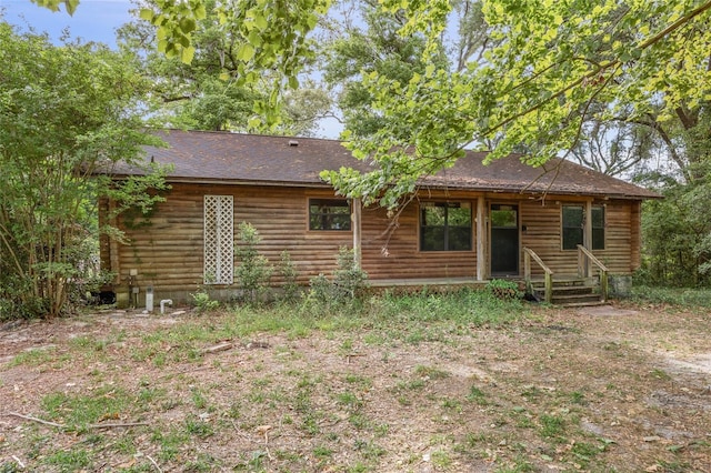 rear view of house with log exterior and roof with shingles