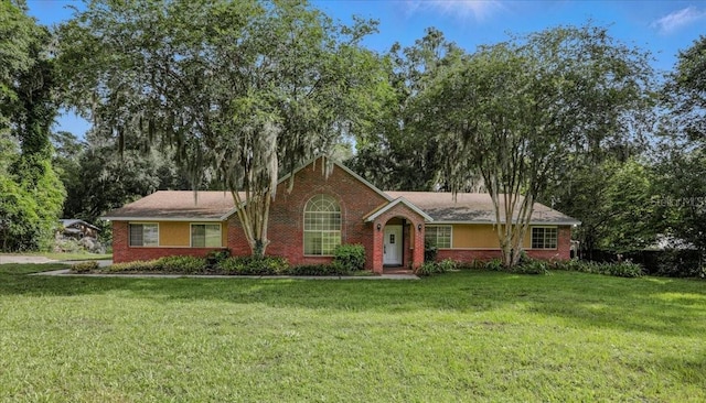7800 SW 24th Ave, Gainesville, FL 32607 - ranch-style house with a front yard and view of wooded area