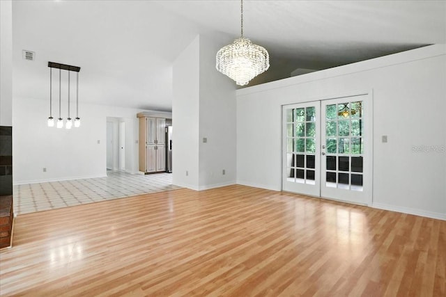 7800 SW 24th Ave, Gainesville, FL 32607 - unfurnished living room featuring light wood-style flooring, a chandelier, and vaulted ceiling