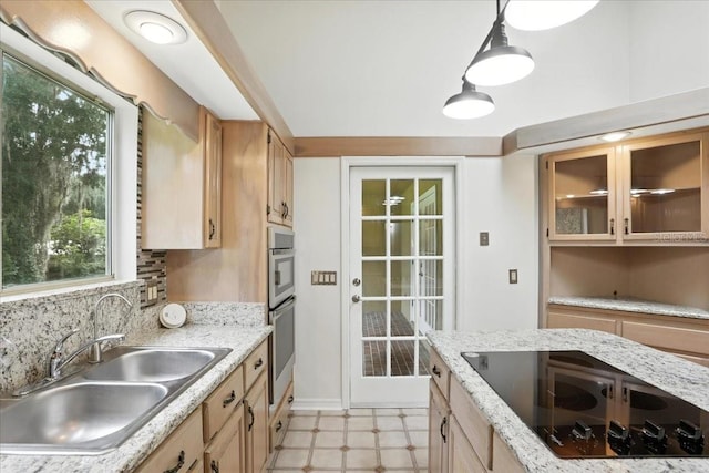 7800 SW 24th Ave, Gainesville, FL 32607 - kitchen featuring black electric cooktop, light flooring, pendant lighting, light brown cabinetry, and glass insert cabinets