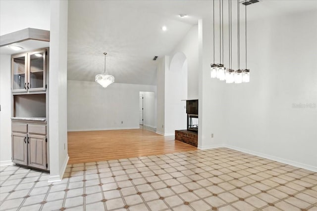 7800 SW 24th Ave, Gainesville, FL 32607 - unfurnished living room featuring arched walkways, light floors, and lofted ceiling