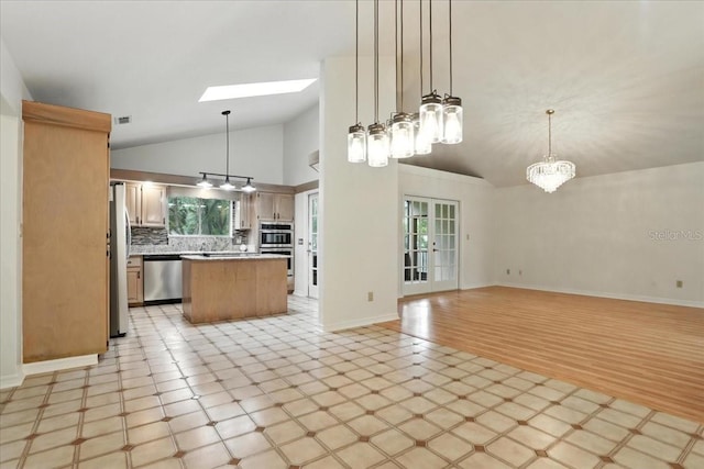 7800 SW 24th Ave, Gainesville, FL 32607 - kitchen featuring stainless steel appliances, vaulted ceiling, open floor plan, light countertops, and a center island