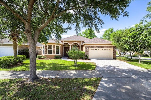view of front facade featuring a garage, a front lawn, fence, stucco siding, and driveway