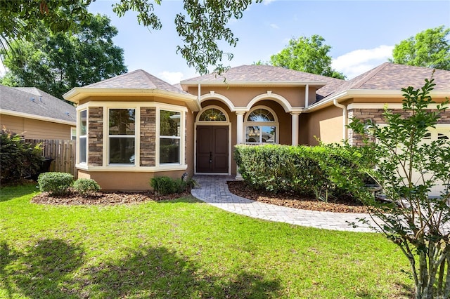 property entrance featuring fence, stucco siding, a yard, and a shingled roof