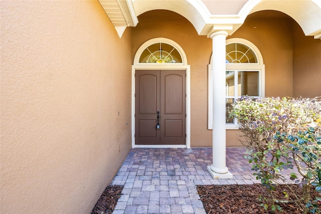entrance to property featuring stucco siding