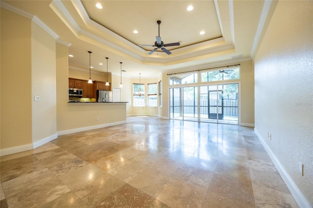 unfurnished living room featuring a ceiling fan, baseboards, ornamental molding, a tray ceiling, and recessed lighting