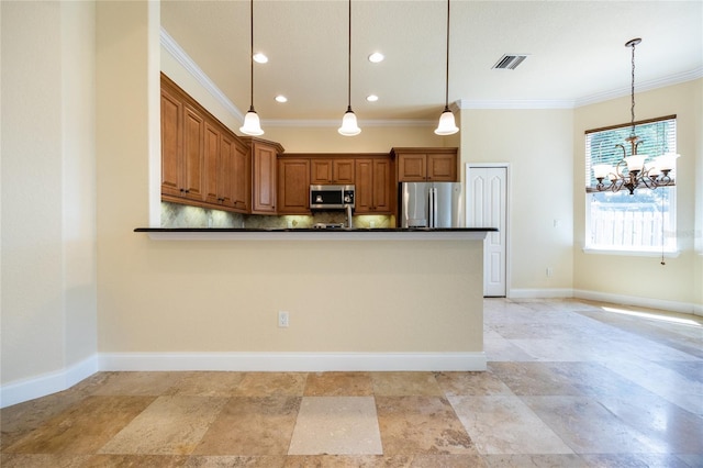 kitchen featuring crown molding, dark countertops, a notable chandelier, appliances with stainless steel finishes, and pendant lighting