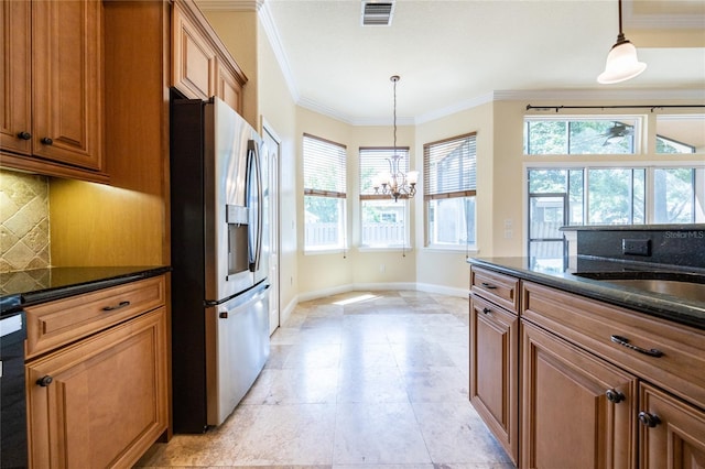 kitchen with stainless steel fridge, brown cabinetry, baseboards, tasteful backsplash, and visible vents