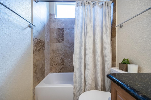 bathroom with vanity, a textured wall, shower / bath combo with shower curtain, and toilet