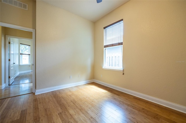 spare room with visible vents, baseboards, ceiling fan, and wood finished floors