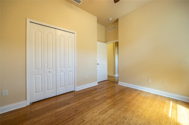unfurnished bedroom featuring baseboards, visible vents, and wood finished floors