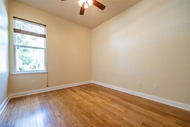 unfurnished room with ceiling fan, vaulted ceiling, baseboards, and light wood finished floors