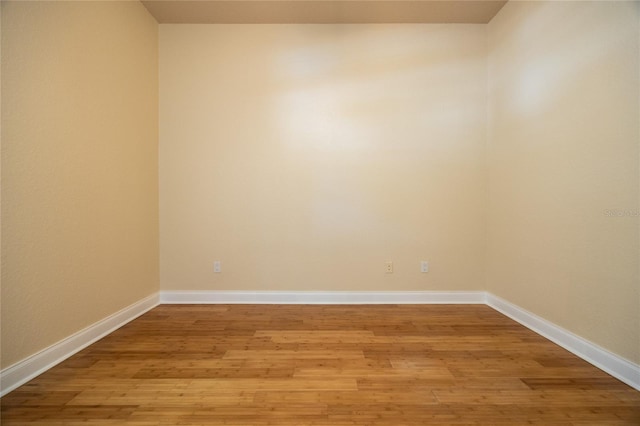 unfurnished room with baseboards and light wood finished floors
